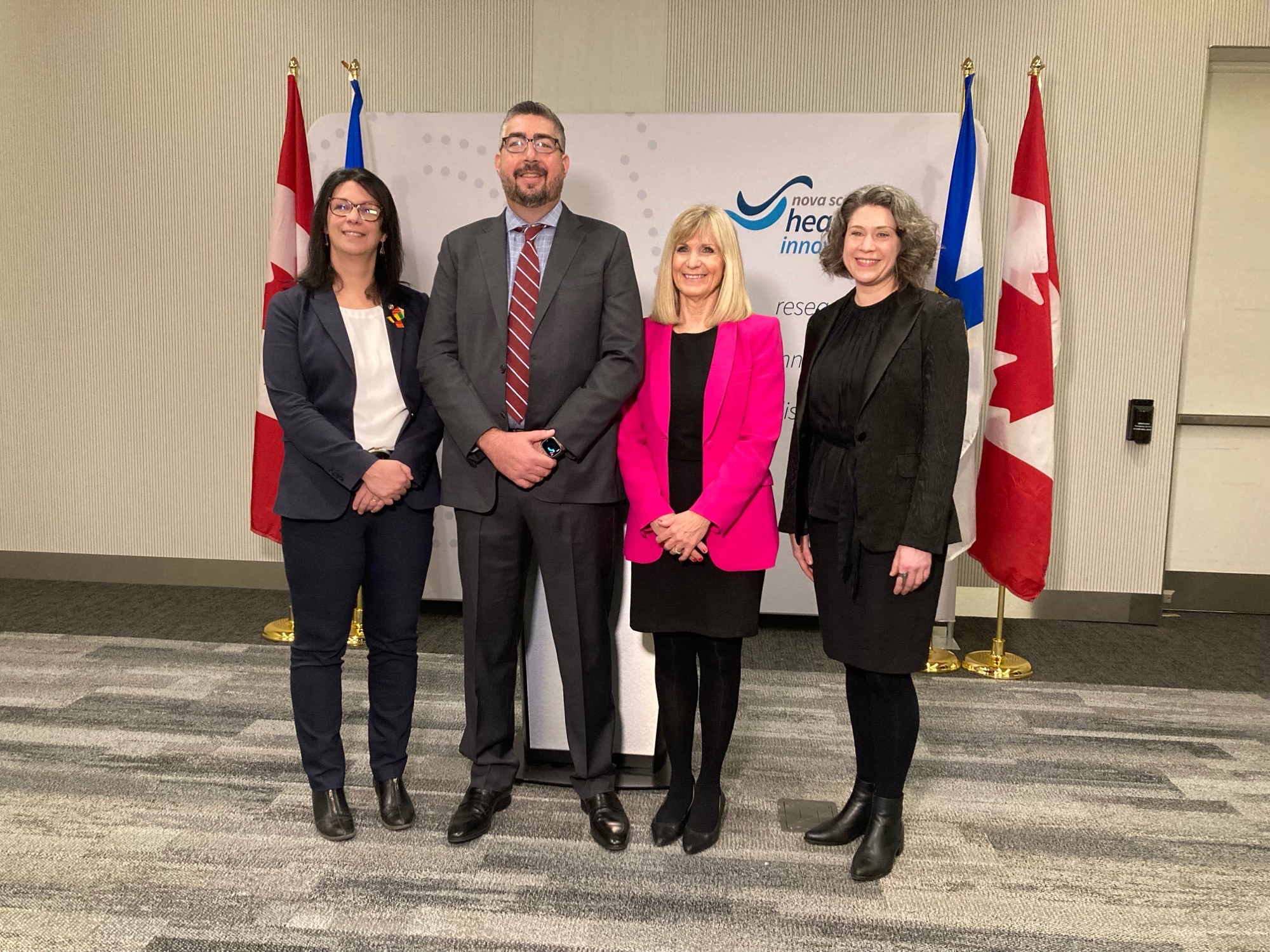 4 people standing in front of NS Health backdrop