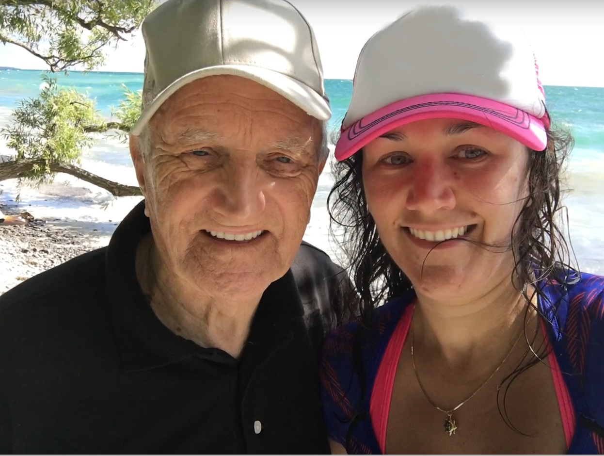 Karen and her grandfather at the beach wearing hats