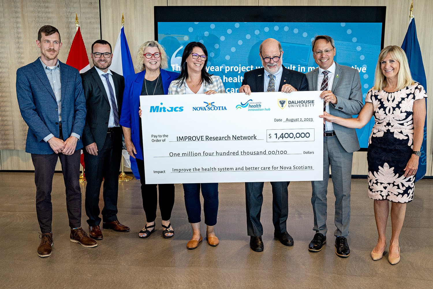 A group of people holding a large cheque at the Mitacs announcement