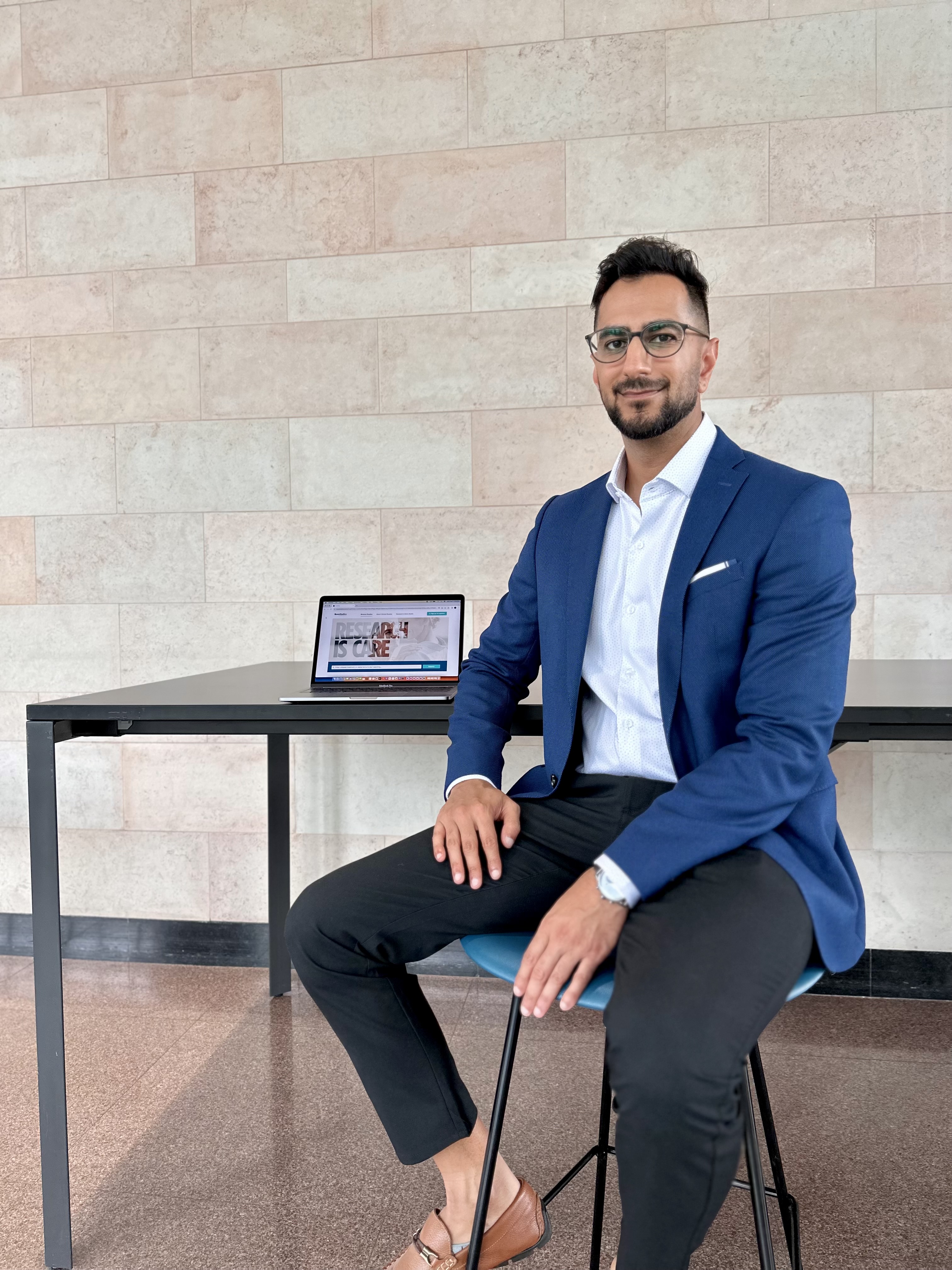 Jay Virani sits on a chair, next to an iPad.
