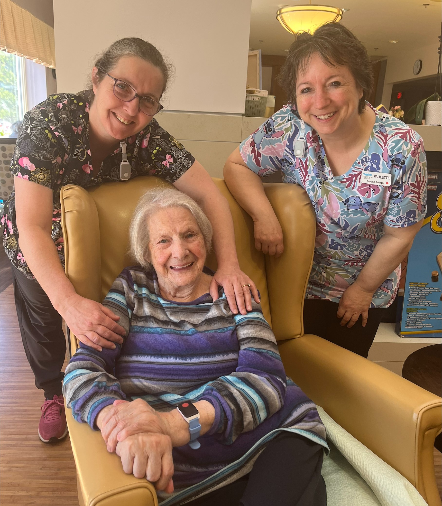 Photo of Tideview staff with resident wearing the Tenera Care technology on their wrist.