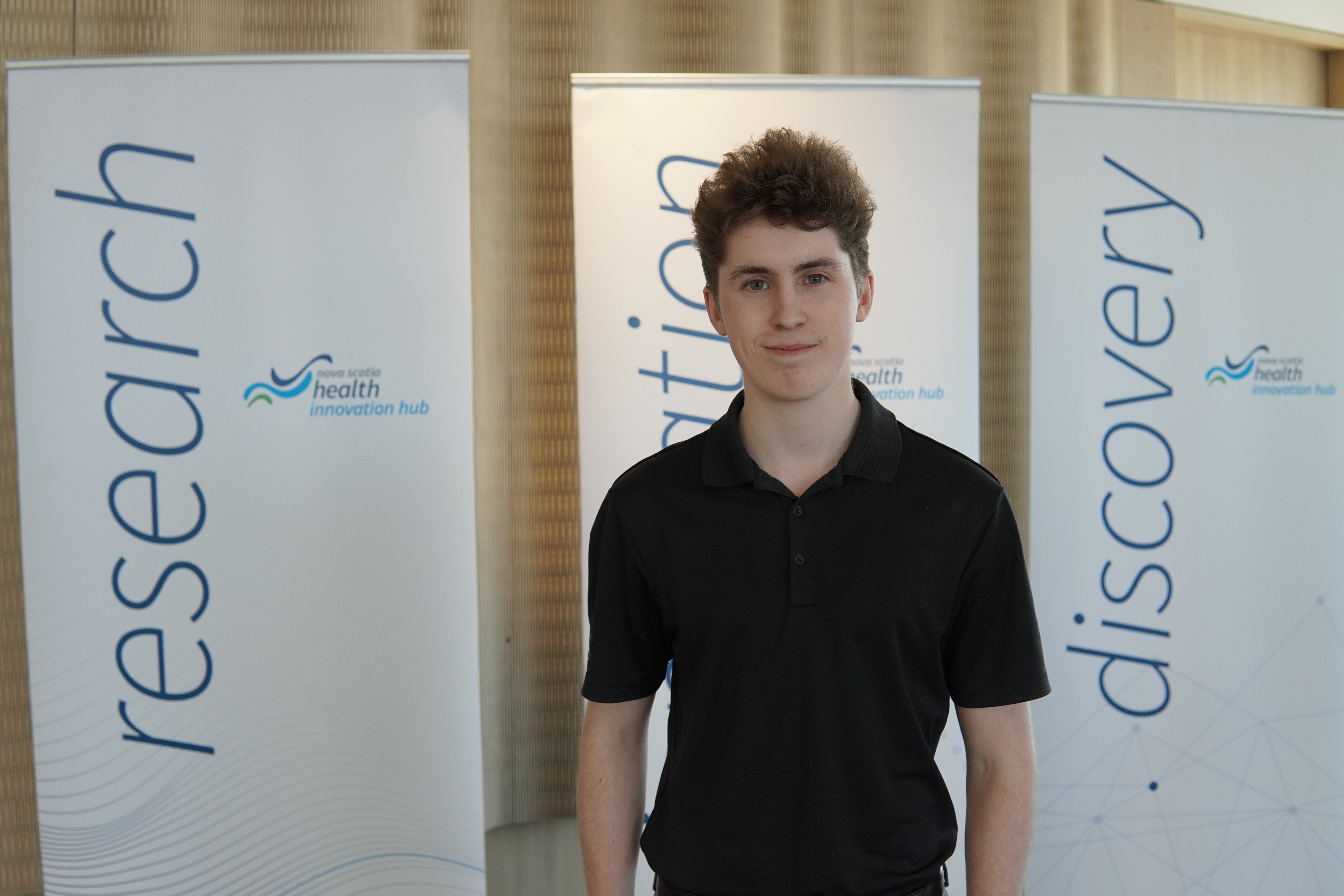 Dalhousie University industrial engineering student Trent Rice smiles at the camera, wearing a black polo shirt.