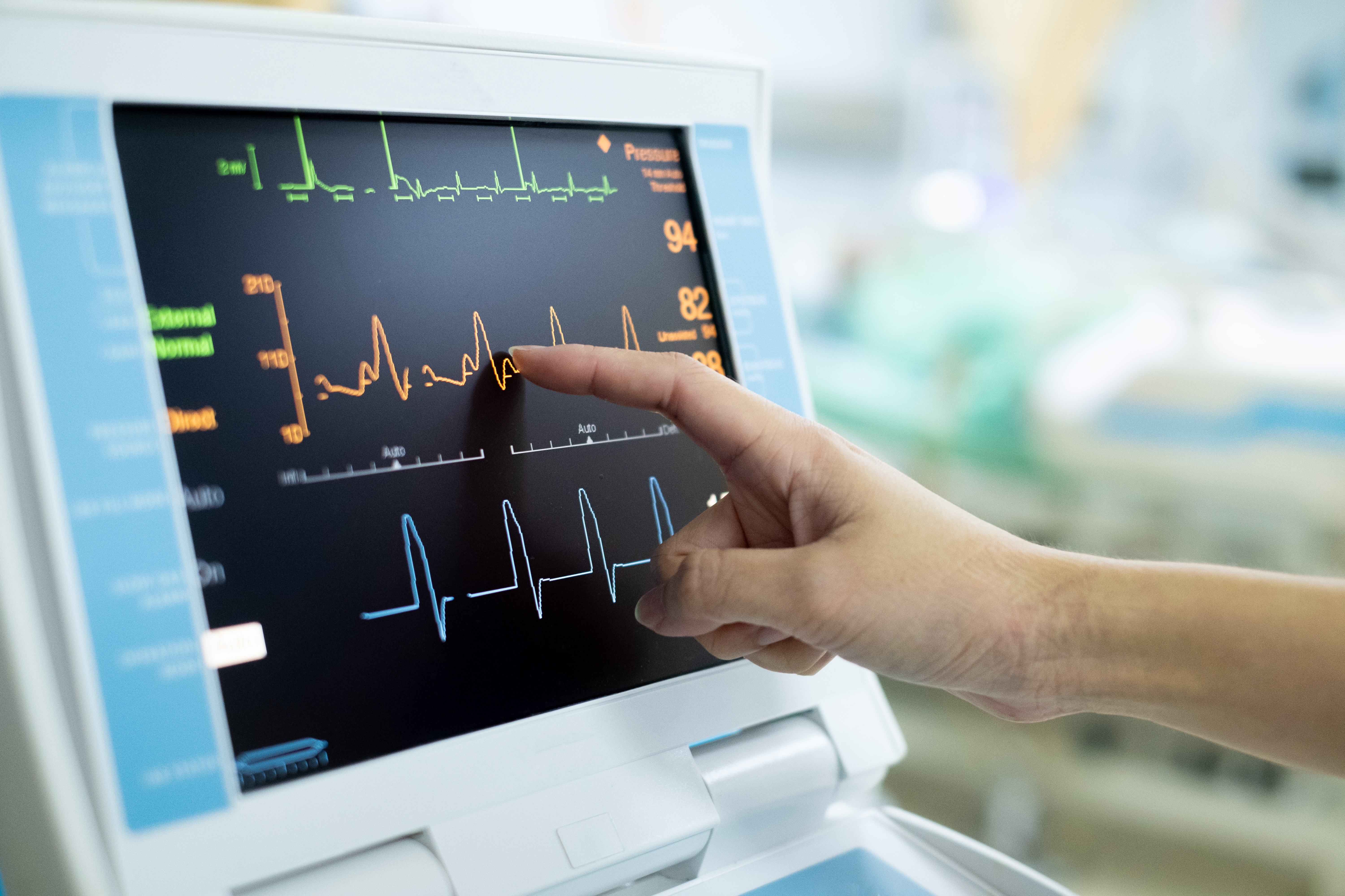 A healthcare worker touches and EKG screen