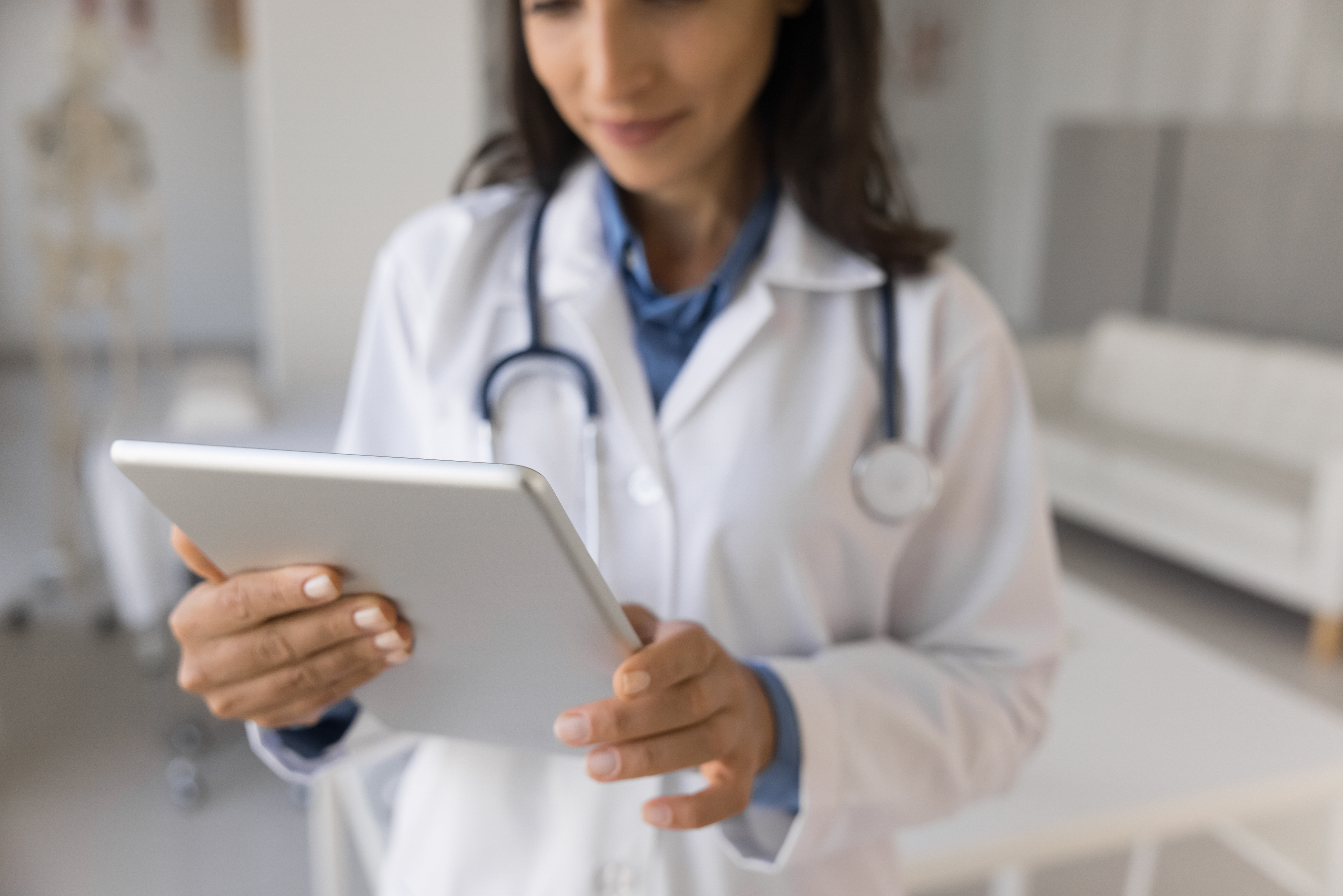 A female doctor looks at an iPad