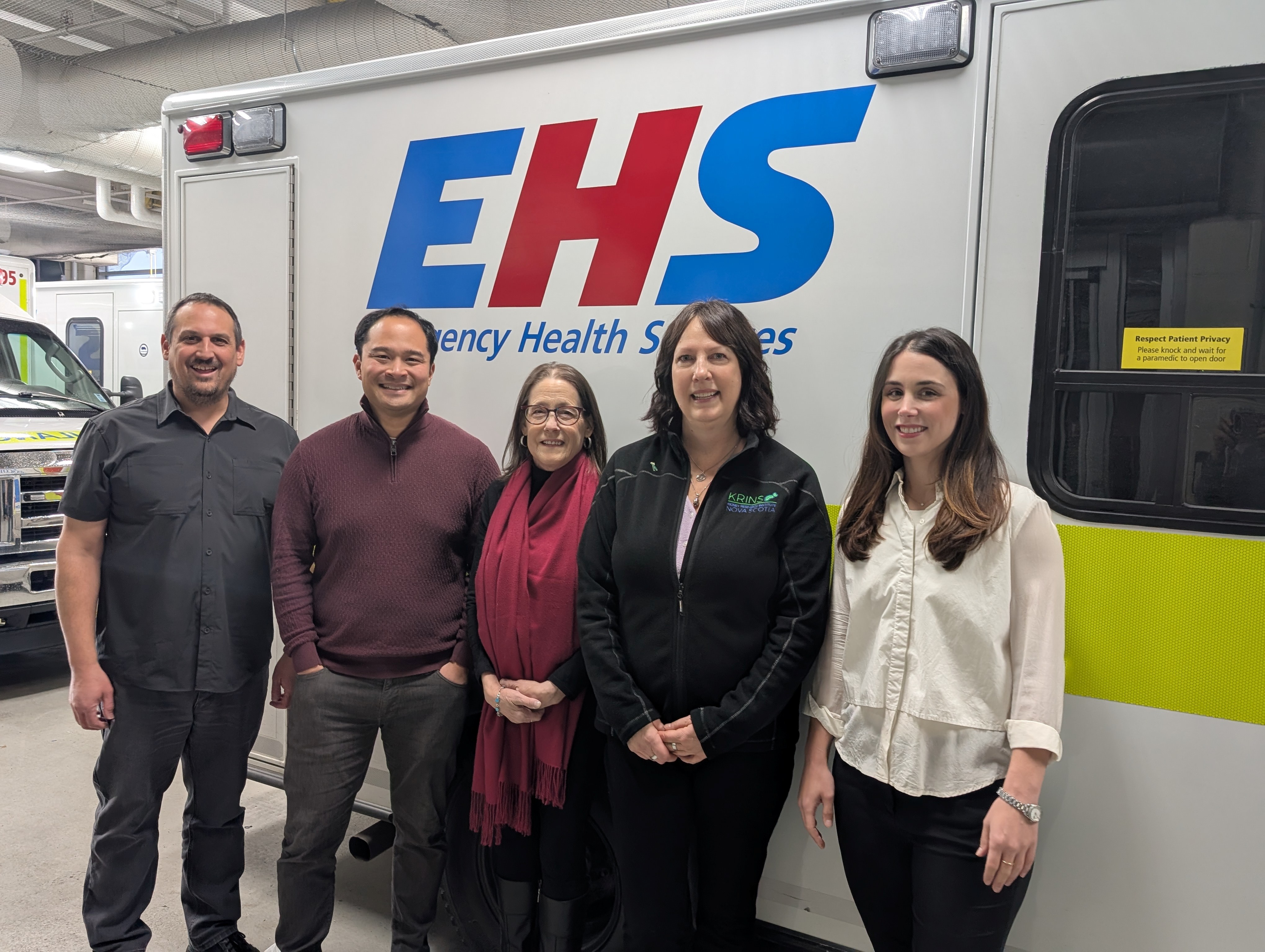 Dr. Patrick Fok and team in front of an ambulance