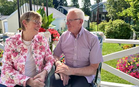 Debbie Purchase and her husband Michael McGill smile at each other in a sunny garden.