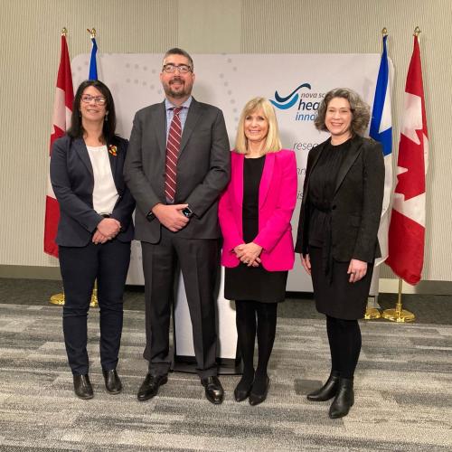 4 people standing in front of NS Health backdrop