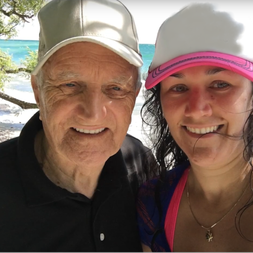 Karen and her grandfather at the beach wearing hats