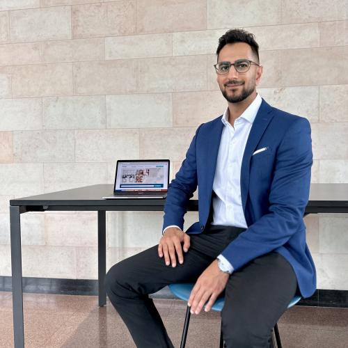Jay Virani sits on a chair, next to an iPad.