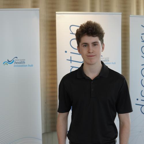 Dalhousie University industrial engineering student Trent Rice smiles at the camera, wearing a black polo shirt.
