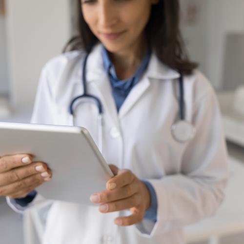 A female doctor looks at an iPad