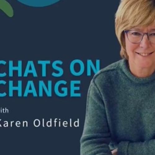 Karen Oldfield smiling at the camera with a cup of coffee