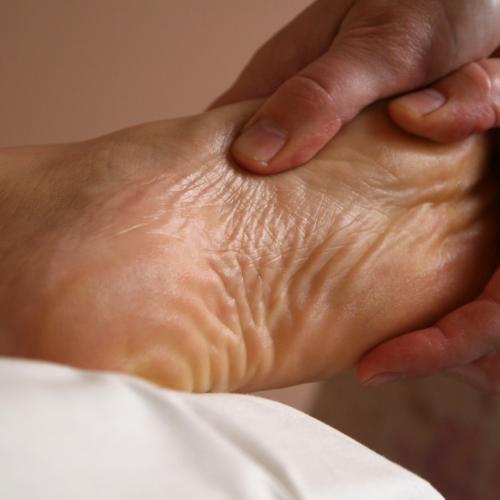 Hands massage a foot.